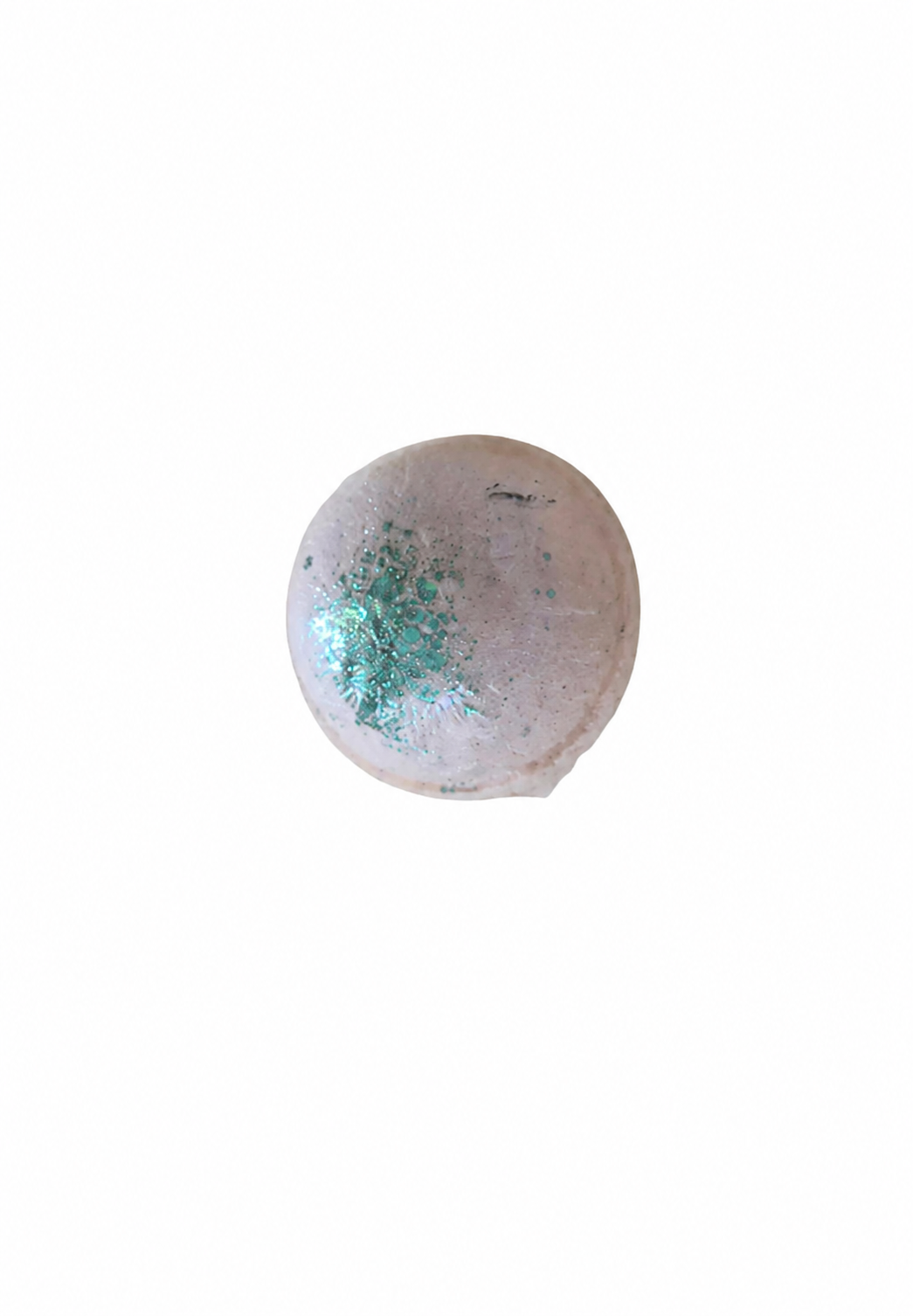 Boule de bain mangue effervescente rose pâle avec décoration verte sur fond blanc.