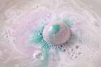 Boule de bain mangue effervescente dans l’eau avec mousse relaxante.