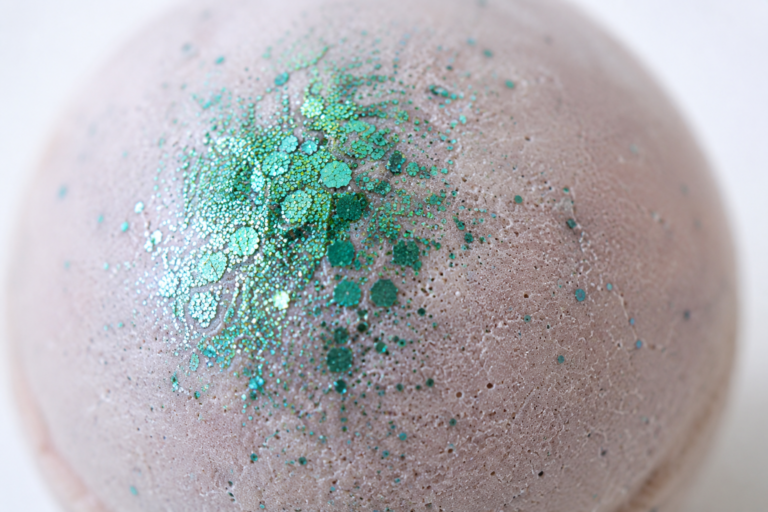 Gros plan texture de la boule de bain mangue avec détails scintillants verts.