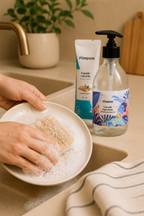 Liquide vaisselle Pimpant utilisé avec mousse sur éponge dans une cuisine minimaliste naturelle
