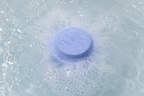 Palet effervescent en train de fondre dans le bain moussant
