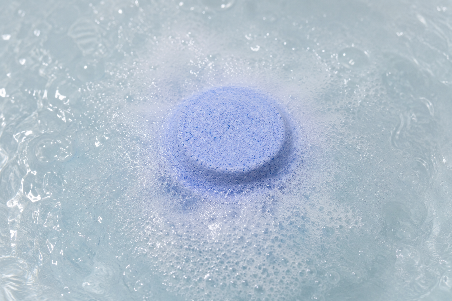Palet effervescent en train de fondre dans le bain moussant