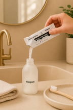 Recharge dentifrice blancheur Pimpant versée dans un flacon ouvert dans une salle de bain beige