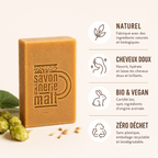 Savon bio artisanal avec packaging rouge dans une douche premium