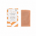 Savon solide naturel avec packaging orange et décor salle de bain beige minimaliste