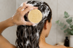 Shampoing solide naturel en utilisation avec mousse dans les cheveux sous la douche